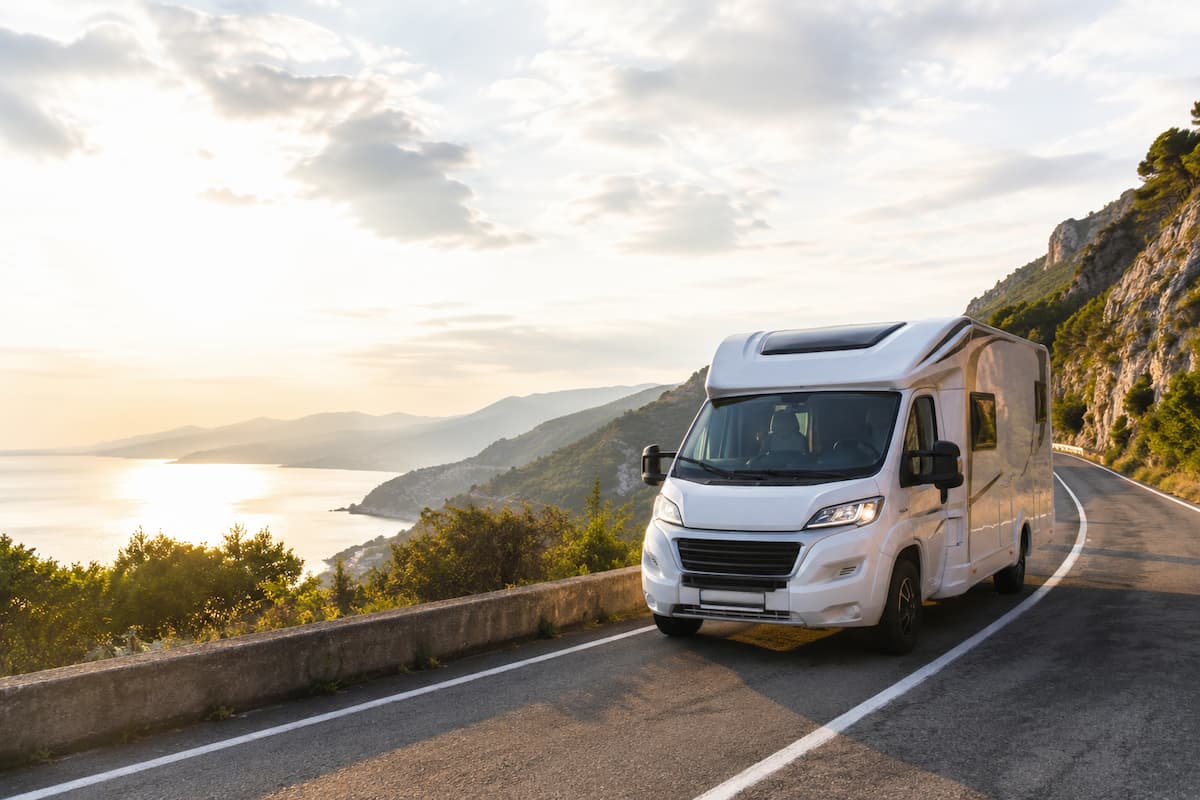 Autocaravana en ruta por una carretera costera, ejemplo de viaje para elegir las coberturas adecuadas en un seguro de autocaravana.